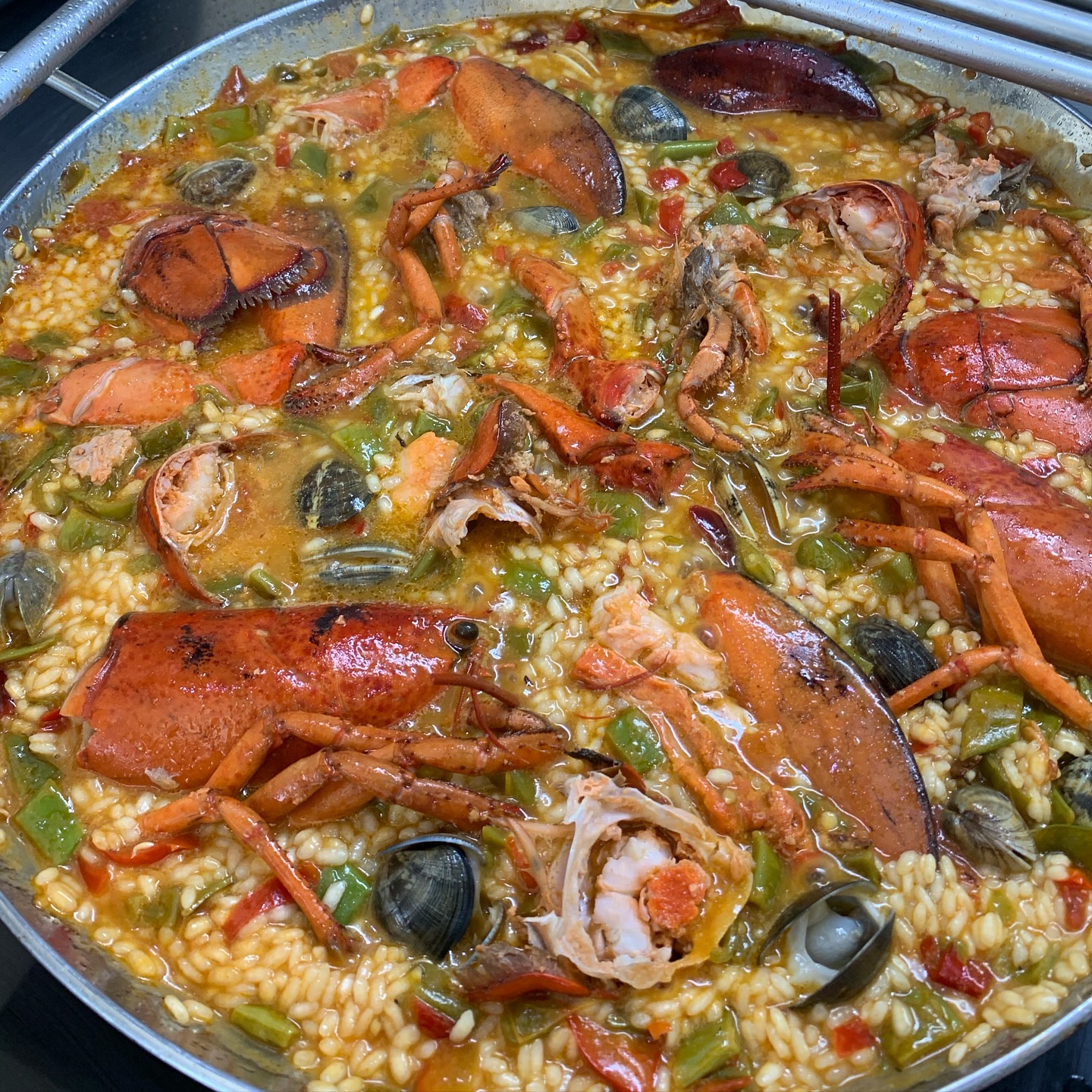 Paella de langosta servida en paellera